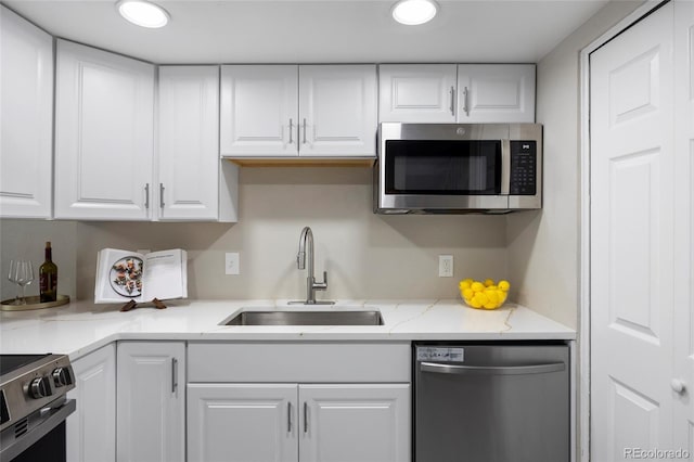 2856 S Kenton Ct, Aurora, CO 80014 - kitchen with stainless steel appliances, white cabinetry, light stone countertops, and recessed lighting