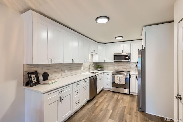610 S Clinton St Unit 5A, Denver, CO 80247 - kitchen with stainless steel appliances, decorative backsplash, white cabinets, and light countertops