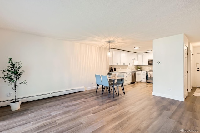 610 S Clinton St Unit 5A, Denver, CO 80247 - dining room featuring light wood-style flooring and baseboard heating