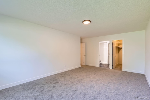 610 S Clinton St Unit 5A, Denver, CO 80247 - unfurnished bedroom with a spacious closet, carpet, and a textured ceiling
