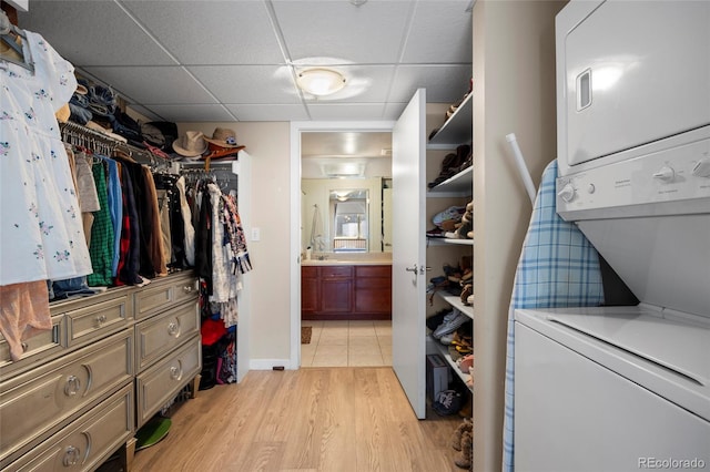 1475 Delgany St Unit 307, Denver, CO 80202 - spacious closet featuring stacked washing machine and dryer, light wood-style floors, and a drop ceiling