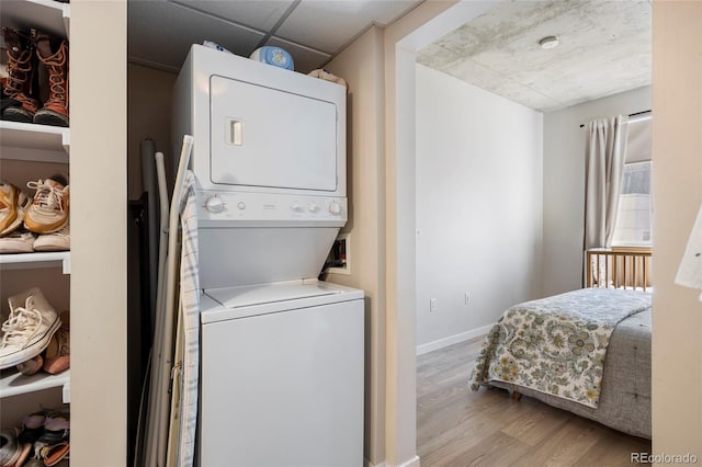 1475 Delgany St Unit 307, Denver, CO 80202 - washroom featuring estacked washer and dryer and wood finished floors