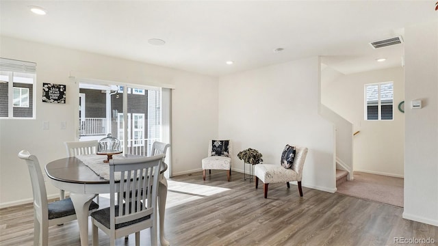 dining room featuring stairs, baseboards, visible vents, and light wood-style floors