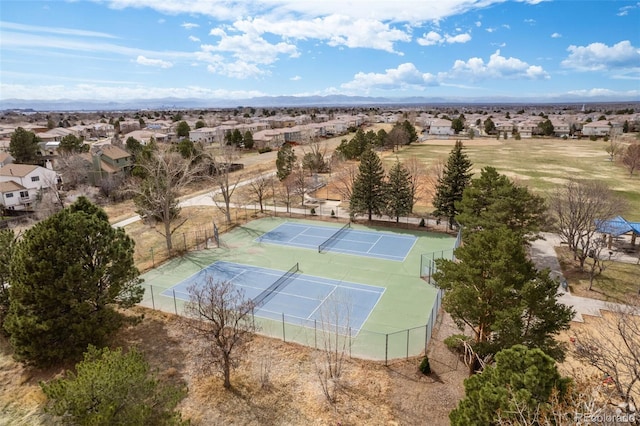 view of tennis court with a residential view and fence