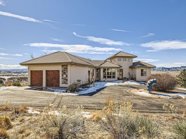 view of front of property with a garage, a tile roof, and stucco siding