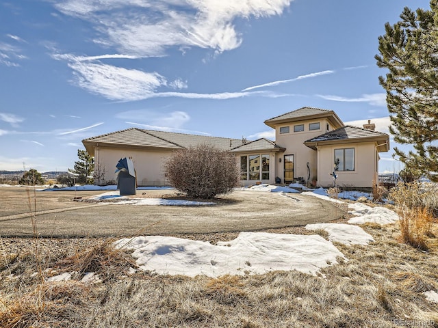 view of front of home with a tile roof and stucco siding