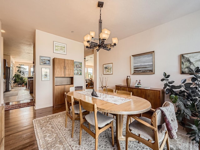 dining space with an inviting chandelier, plenty of natural light, baseboards, and hardwood / wood-style floors