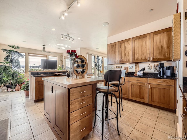 kitchen featuring a wealth of natural light, a kitchen island, and light tile patterned floors