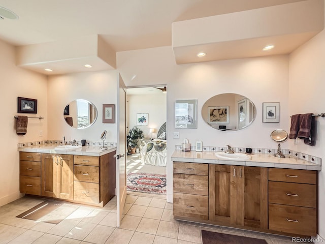 bathroom featuring two vanities, connected bathroom, and a sink