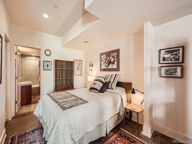 bedroom featuring ensuite bath, baseboards, and recessed lighting