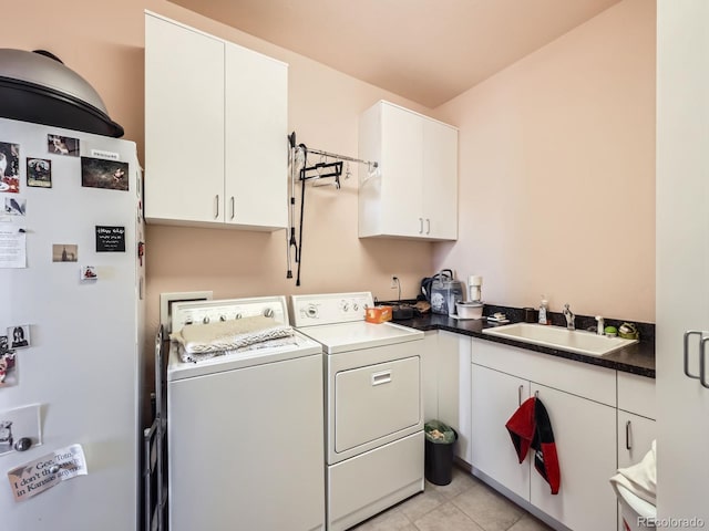 laundry area featuring light tile patterned flooring, cabinet space, a sink, and separate washer and dryer