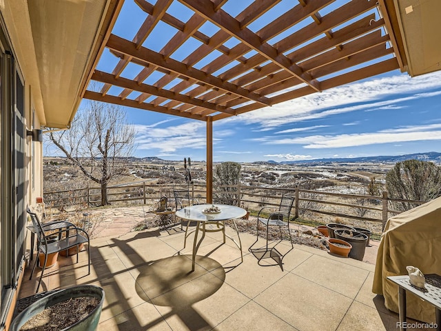 view of patio / terrace with outdoor dining area, a mountain view, and a pergola