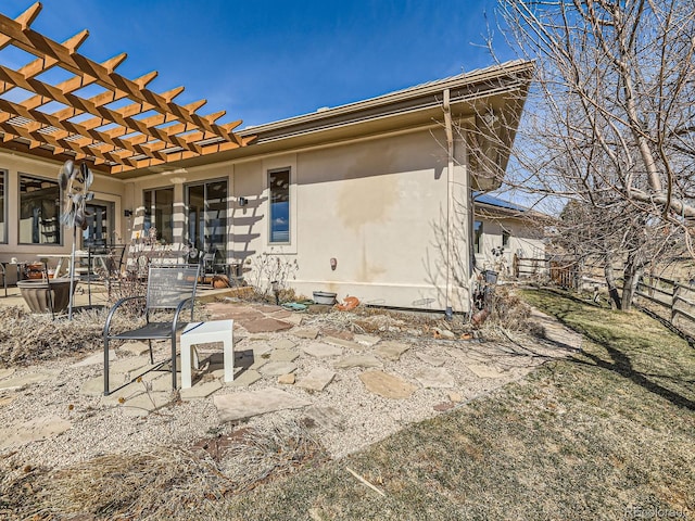 back of house featuring stucco siding, a patio area, and a pergola