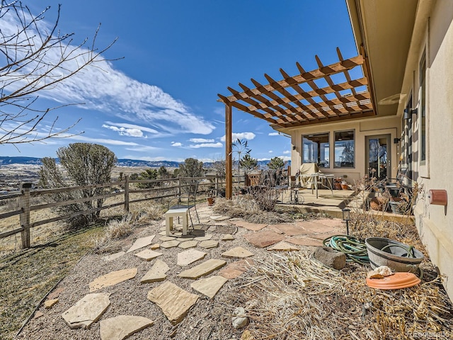 view of patio / terrace featuring a fenced backyard, a mountain view, and a pergola