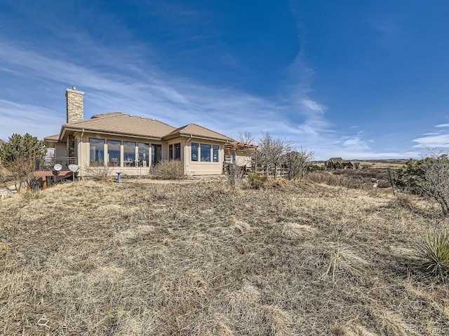 rear view of property featuring a chimney