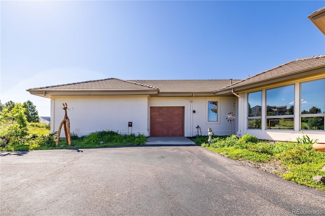 8611 Coachlight Way, Littleton, CO 80125 - view of front of property with an attached garage, stucco siding, a tiled roof, and driveway