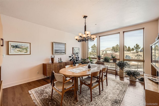 8611 Coachlight Way, Littleton, CO 80125 - dining area with a chandelier, wood-type flooring, and baseboards