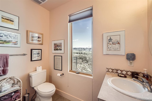 8611 Coachlight Way, Littleton, CO 80125 - half bath featuring vanity, toilet, healthy amount of natural light, and tile patterned flooring