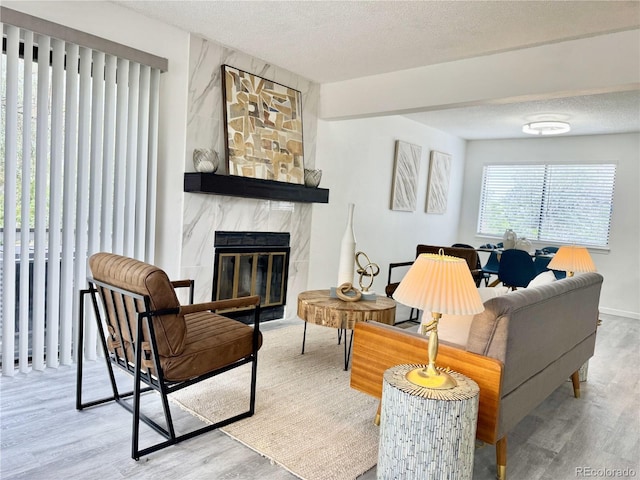 180 S Nome St, Aurora, CO 80012 - living area with wood finished floors, a premium fireplace, a textured ceiling, and baseboards