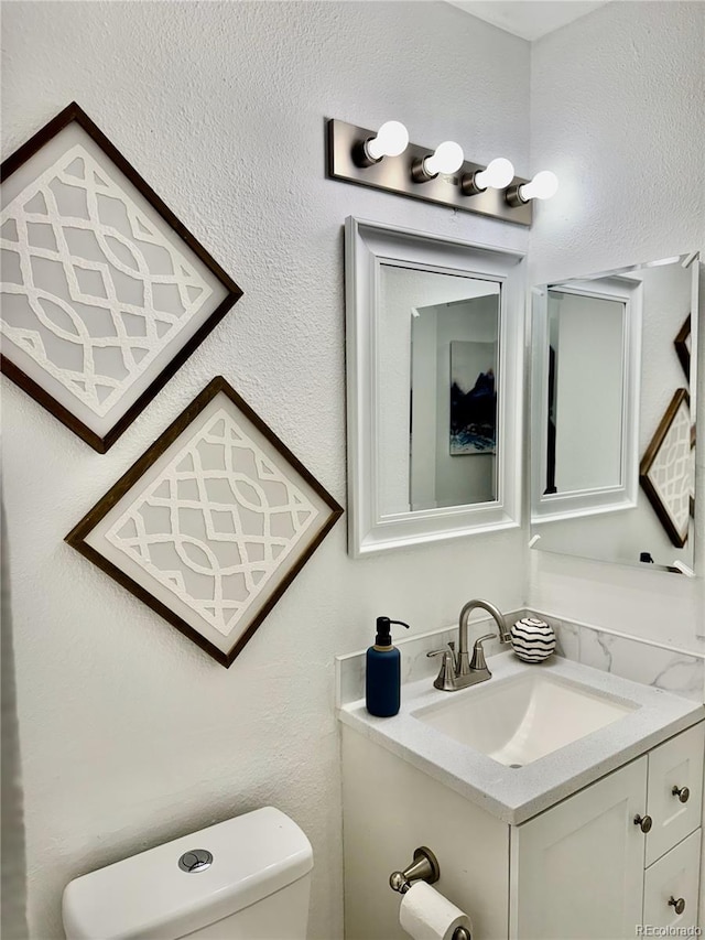 180 S Nome St, Aurora, CO 80012 - bathroom with toilet, vanity, and a textured wall