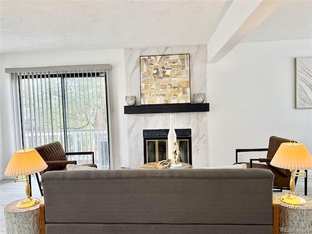 180 S Nome St, Aurora, CO 80012 - living area featuring a textured ceiling, a premium fireplace, and wood finished floors