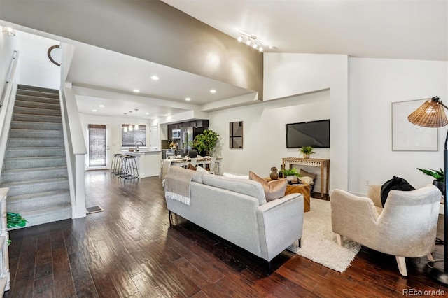 living area with dark wood-type flooring, stairway, and recessed lighting