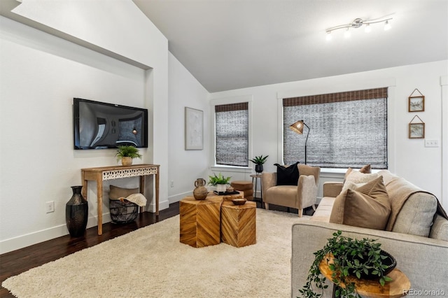 living room with vaulted ceiling, baseboards, and wood finished floors