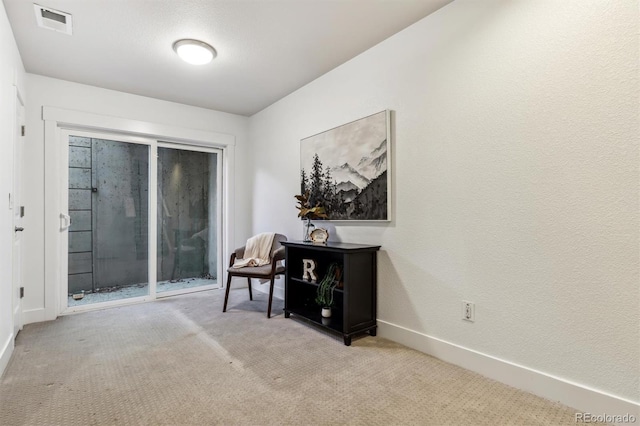 sitting room featuring carpet floors and baseboards