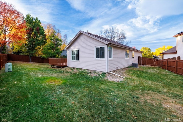 back of house featuring a lawn and a wooden deck