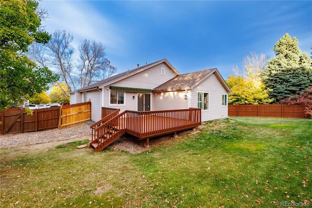 rear view of house with a lawn and a deck