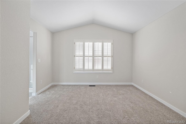 empty room with carpet and vaulted ceiling