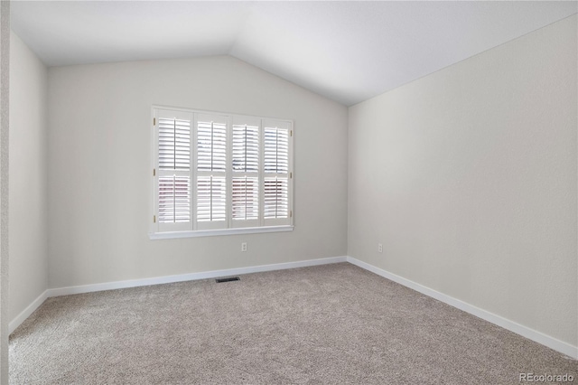 carpeted empty room featuring lofted ceiling