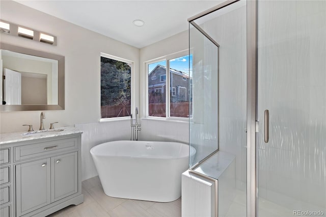 bathroom featuring tile patterned floors, vanity, tile walls, and shower with separate bathtub