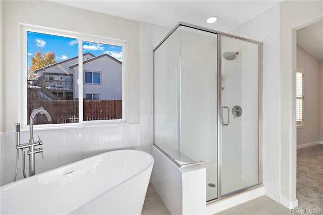 bathroom featuring shower with separate bathtub