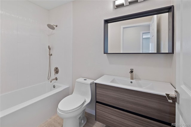 full bathroom featuring tiled shower / bath, vanity, and toilet