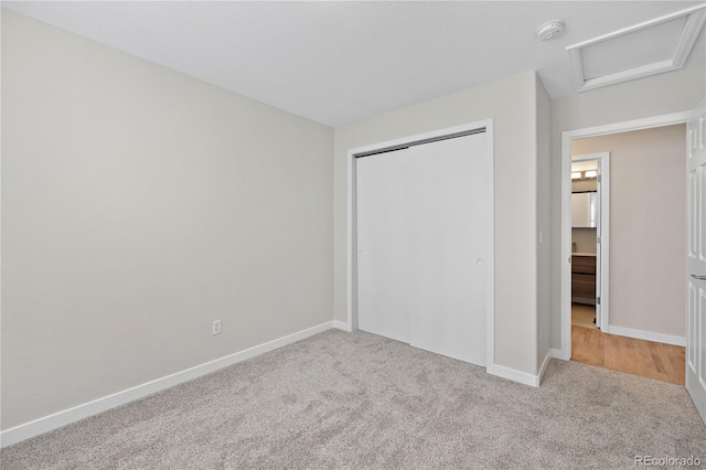 unfurnished bedroom with a closet and light colored carpet