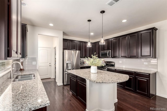 690 W 172nd Pl, Broomfield, CO 80023 - kitchen featuring appliances with stainless steel finishes, a kitchen island, light stone counters, dark wood-style flooring, and recessed lighting