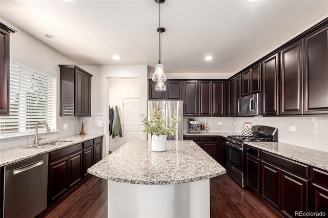 690 W 172nd Pl, Broomfield, CO 80023 - kitchen with appliances with stainless steel finishes, a center island, dark wood-type flooring, tasteful backsplash, and recessed lighting