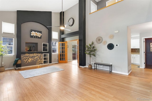 entryway featuring light wood-type flooring and high vaulted ceiling