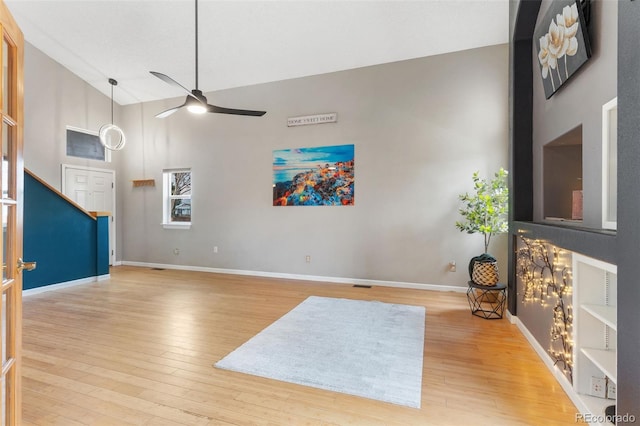 living room with ceiling fan, high vaulted ceiling, and light hardwood / wood-style floors