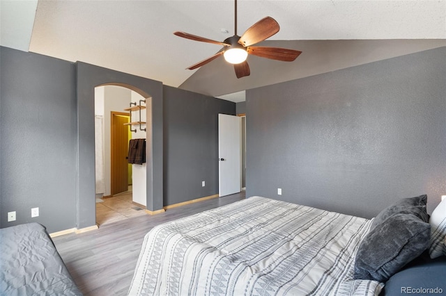 bedroom featuring ceiling fan, light wood-type flooring, and lofted ceiling