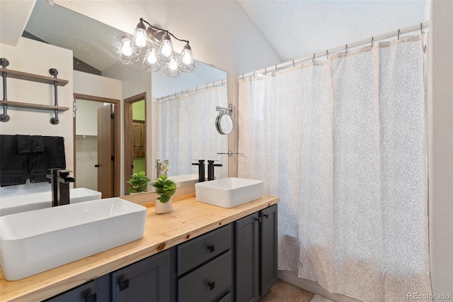 bathroom featuring an inviting chandelier, vanity, vaulted ceiling, and a shower with shower curtain