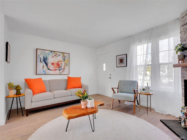 living area with a fireplace, wood finished floors, and baseboards
