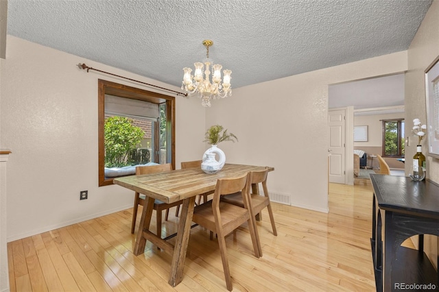 9025 Jellison Ct, Broomfield, CO 80021 - dining area featuring light wood finished floors, a chandelier, and a textured ceiling
