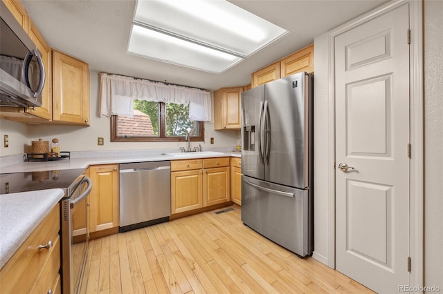 9025 Jellison Ct, Broomfield, CO 80021 - kitchen with stainless steel appliances, light wood finished floors, light brown cabinetry, and light countertops