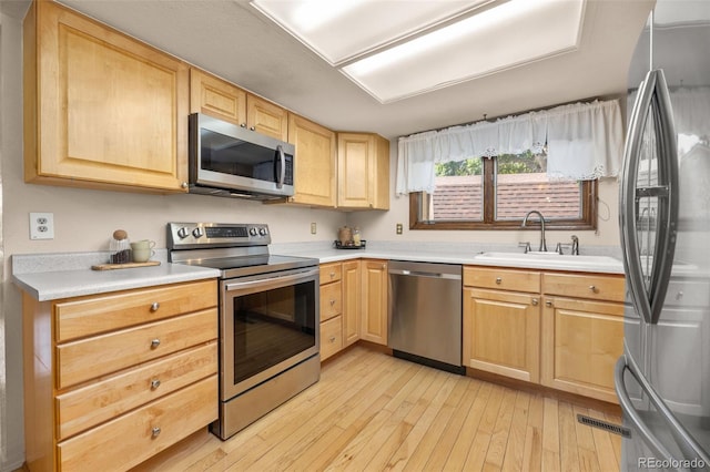 9025 Jellison Ct, Broomfield, CO 80021 - kitchen with appliances with stainless steel finishes, light brown cabinets, light wood-type flooring, and light countertops