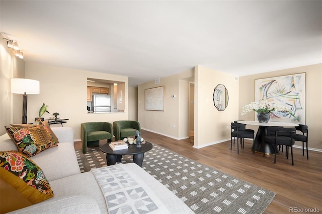 living room featuring visible vents, wood finished floors, and baseboards