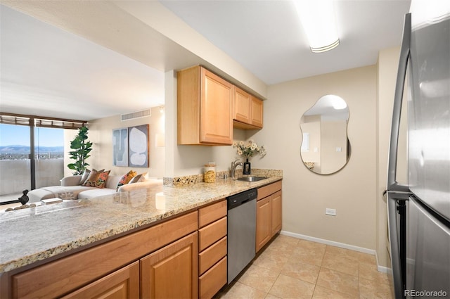kitchen featuring a sink, stainless steel appliances, visible vents, baseboards, and light stone counters