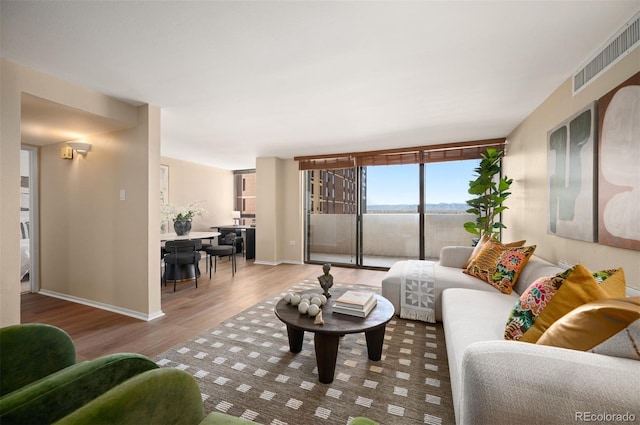 living room with visible vents, wood finished floors, and baseboards