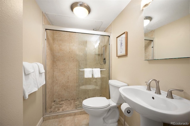 full bath featuring a stall shower, toilet, baseboards, a sink, and tile patterned floors